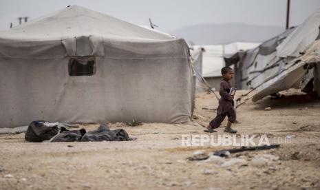 Seorang anak laki-laki memegang buku saat berjalan di kamp al-Hol, yang menampung keluarga anggota kelompok Negara Islam, di provinsi Hasakeh, Suriah, Sabtu, 1 Mei 2021. 