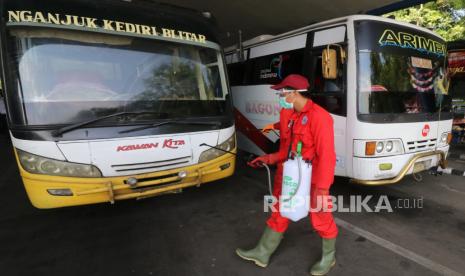 Petugas Dinas Kesehatan menyemprotkan cairan disinfektan di area terminal. Ilustrasi