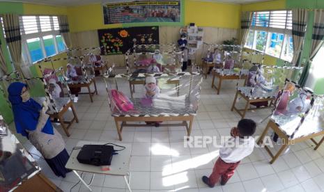 Sejumlah murid mengikuti kegiatan belajar secara tatap muka menggunakan meja bersekat plastik, di Sekolah Dasar Negeri (SDN) 09 Pasar Pandan Airmati (PPA), Kec. Tanjung Harapan, Kota Solok, Sumatera Barat, Jumat (24/7/2020). Sekolah tersebut memberlakukan belajar tatap muka bagi kelas 1 untuk uji coba pelaksanaan pembelajaran luring (luar jaringan) sekaligus memperkenalkan sekolah, dengan menerapkan protokol kesehatan COVID-19. ANTARA FOTO/Iggoy el Fitra/foc.