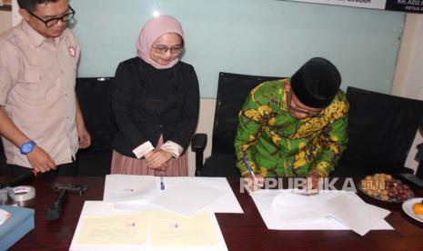 Ketua PCNU Kabupaten Cirebon, KH Aziz Hakim Syaerozi, saat melakukan penandatanganan kerja sama dengan Kementerian Kominfo RI, Kamis (29/2/2024).  