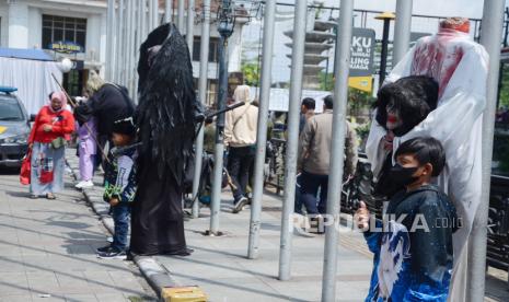 Pengunjung berfoto bersama para cosplayer berpenampilan hantu, super hero dan tokoh anime di tempat wisata cosplay di kawasan Gedung Merdeka, Jalan Sukarno, Kota Bandung, Ahad (8/5). Keterisian hotel di Kota Bandung mencapai 78 persen selama libur lebaran.