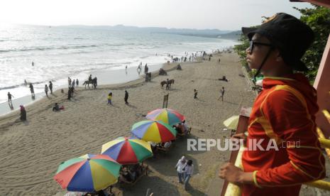 Penjaga pantai mengawasi wisatawan di kawasan Pantai Citepus, Palabuhanratu, Kabupaten Sukabumi, Jawa Barat, Ahad (24/12/2023). Menurut pengelola setempat, jumlah kunjungan wisatawan mengalami peningkatan sebesar 50 persen saat libur Natal dan tahun baru 2024. 