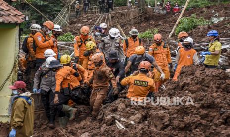 Petugas gabungan mengevakuasi korban yang tertimbun longsor di Desa Cihanjuang, Kecamatan Cimanggung, Kabupaten Sumedang, Ahad (10/1). Longsor yang disebabkan oleh kondisi tanah tidak stabil dan curah hujan tinggi pada Sabtu (9/1) mengakibatkan sekitar 14 rumah rusak berat dan 12 orang meninggal dunia serta belasan orang lainnya masih dalam pencarian.