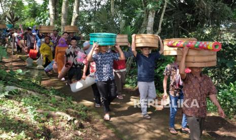 Warga mengusung tenong berisi berbagai jenis makanan saat tradisi Nyadran Perdamaian di Krecek, Getas, Kaloran, Temanggung, Jateng, Jumat (12/1/2024). Tradisi nyadran atau merti dusun yang diikuti penganut agama Islam, Budha, dan Katolik tersebut merupakan tradisi turun temurun sebagai bentuk toleransi dan kerukunan warga lintas agama sekaligus berdoa untuk kelancaran Pemilu 2024. 