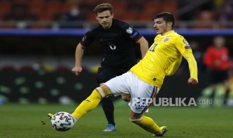 Valentin Mihaila (kanan) Rumania beraksi melawan Joshua Kimmich (kiri) dari Jerman selama pertandingan sepak bola kualifikasi Piala Dunia FIFA 2022 antara Rumania dan Jerman di Bucharest, Rumania, 28 Maret 2021.