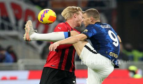 Pemain AC Milan Simon Kjaer (kiri) dan pemain Inter Milan Edin Dzeko berebut bolai saat pertandingan sepak bola Serie A Italia antara AC Milan dan FC Inter di stadion Giuseppe Meazza di Milan, Italia, Senin (8/11) dini hari WIB. 