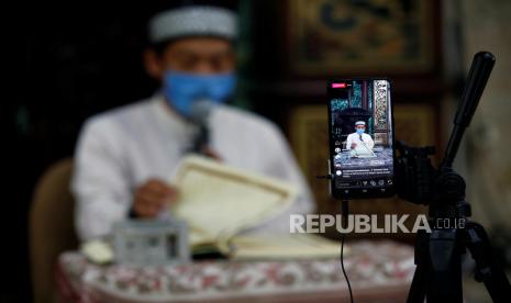 Imam Masjid Sunda Kelapa Jakarta, Bambang Suprianto mengenakan masker saat membacakan Alquran yang disiarkan secara langsung di media sosial menjelang saat berbuka Sabtu, (25/4).