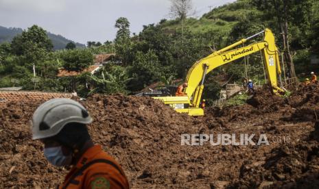 Recuers mencari korban longsor yang melanda sebuah desa di desa Cihanjuang, Jawa Barat, Indonesia, Selasa, 12 Januari 2021. Sejumlah orang tewas dan terluka dalam longsor yang dipicu oleh hujan deras pada hari Minggu di desa di Kabupaten Sumedang Jawa Barat. Beberapa korban merupakan penyelamat dari bencana longsor sebelumnya.