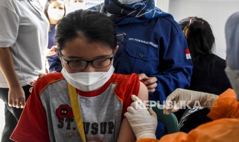 Vaksinator menyuntikkan vaksin Covid-19 ke seorang anak di Taman Dewi Sartika, Jalan Wastukencana, Kota Bandung, Selasa (4/1). Pemerintah akan memulai vaksinasi Covid-19 dosis ketiga atau vaksinasi booster pada 12 Januari 2022 mendatang. Vaksinasi booster tersebut diberikan kepada 244 kabupaten/kota yang capaian vaksinasi telah memenuhi kriteria 70 persen dosis pertama dan 60 persen dosis kedua. Foto: Republika/Abdan Syakura