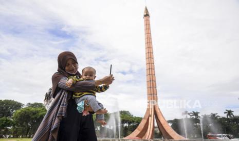 Pengunjung berfoto di area Tugu Api di Taman Mini Indonesia Indah (TMII), Jakarta (ilustrasi) 