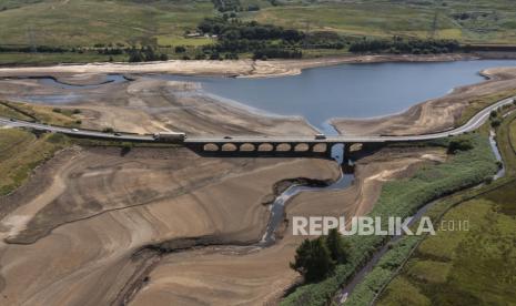 Lalu lintas melintasi jembatan di Woodhead Reservoir di West Yorkshire, Inggris, Senin, 18 Juli 2022 saat permukaan air turun sangat rendah di tengah rekor suhu tinggi di Inggris. Peringatan 