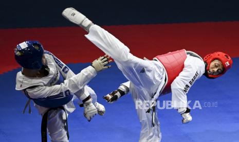 Atlet taekwondo putra Jawa Barat Adam Yazid Ferdyansyah (kanan) melepas tendangan ke arah atlet taekwondo putra Kepulauan Riau Samuel Jason Sumarli (kiri) saat pertandingan semifinal Taekwondo kategori Kyorugi kelas -68 Kg putra PON Papua di GOR Politeknik Penerbangan Kayu Batu, Kota Jayapura, Papua, Senin (4/10/2021). 