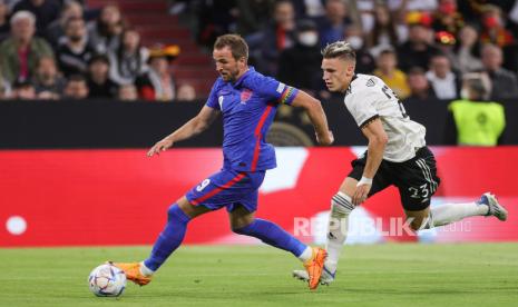 Pemain Inggris Harry Kane (kiri) dan pemain Jerman Nico Schlotterbeck (kanan) beraksi selama pertandingan sepak bola UEFA Nations League antara Jerman dan Inggris di Munich, Jerman, Selasa (7/6/2022)..