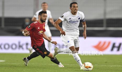 Bruno Fernandes (kiri) dari Manchester United beraksi melawan Copenhage. Ia diadang kapten Copenhagen Carlos Zeca.