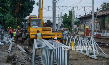 Pekerja memasang tiang listrik aliran atas untuk kereta rel listrik Yogyakarta-Solo di Tukangan, DI Yogyakarta, Sabtu (27/6/2020). Pembangunan jalur kereta rel listrik Yogyakarta-Solo ditargetkan rampung pada Oktober 2020 mendatang untuk menggantikan Kereta Api Prambanan Ekspres (Prameks) guna mendukung transportasi kereta bandara Yogyakarta-Solo. 