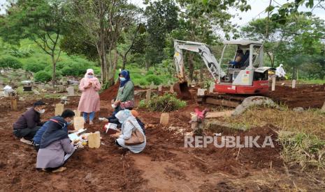 Sebuah ekskavator kecil menggali liang lahat di pemakaman khusus Covid-19 TPU Cikadut, Kota Bandung, Rabu (23/6). Melonjaknya kasus Covid-19 termasuk angka kematian akibat Covid-19 di Kota Bandung, membuat petugas pemakaman menurunkan alat berat untuk mempercepat pembuatan liang lahat.