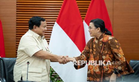 Presiden Prabowo Subianto (kiri) berjabat tangan dengan Menteri Keuangan Sri Mulyani (kanan) usai menyampaikan keterangan pers terkait kenaikan tarif Pajak Pertambahan Nilai (PPN).