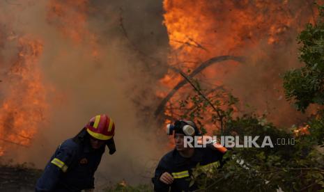  Petugas pemadam kebakaran beroperasi di desa Ellinika di pulau Evia, sekitar 176 kilometer (110 mil) utara Athena, Yunani, Senin, 9 Agustus 2021. Petugas pemadam kebakaran dan penduduk berjuang melawan kebakaran hutan besar-besaran di pulau terbesar kedua Yunani untuk hari ketujuh Senin, berjuang untuk menyelamatkan apa yang mereka bisa dari api yang telah menghancurkan sebagian besar hutan yang masih asli, menghancurkan rumah dan bisnis dan membuat ribuan orang melarikan diri.