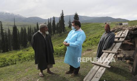 Petugas kesehatan membujuk seorang gembala untuk disuntik vaksin Covid-19 di Tosa Maidan, distrik Budgam Kashmir tengah, India, Senin (21/6). Lokasi yang jauh sekitar 52 kilometer dari Srinagar, India, membuat para tenaga kesehatan harus berjalan melewati hamparan padang rumput dalam mengajak penduduk lokal sekitar untuk menjalani vaksinasi Covid-19. EPA-EFE/FAROOQ KHAN