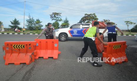 Personel kepolisian membuka pembatas jalan untuk penyekatan di objek wisata Pantai Padang, Sumatra Barat, Rabu (21/7/2021). Pemkot Padang resmi memperpanjang pemberlakuan PPKM terhitung dari 21-25 Juli 2021, dengan perubahan aturan yang diperlonggar, di antaranya mengizinkan pengunjung makan di rumah makan dan kafe maksimal 30 menit, sementara kegiatan operasional hingga pukul 21.00, serta membuka penyekatan di objek wisata. 