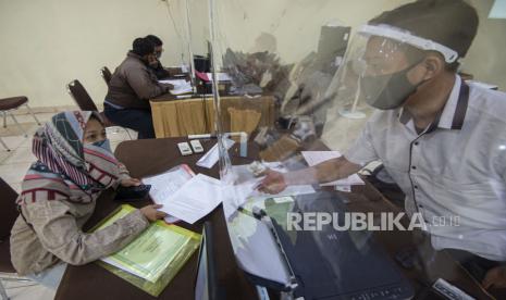 Petugas melayani warga yang melaporkan anaknya usai lolos dalam Penerimaan Peserta Didik Baru (PPDB) tahun ajaran 2020/2021 melalui jalur zonasi di Posko Pelayanan PPDB Jakarta Pusat, Jakarta.