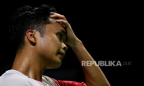 Pebulu tangkis tunggal putra Indonesia Anthony Sinisuka Ginting memegang dahinya saat melawan tunggal putra Denmark Viktor Axelsen dalam laga perempat final Malaysia Open 2022.