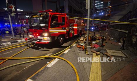 Sejumlah petugas pemadam kebakaran beristirahat secara bergantian dari tugas memadamkan kebakaran gedung utama Kejaksaan Agung di Jakarta, Minggu (23/8/2020). Kebakaran yang berawal sejak Sabtu (22/8) malam itu masih dalam penanganan pihak pemadam kebakaran hingga Minggu pagi. ANTARA FOTO/Aditya Pradana Putra/wsj. 