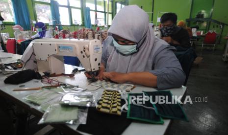 Pekerja menjahit kain saat memproduksi masker di Balai Latihan Kerja (BLK) Boyolali, Teras, Boyolali, Jawa Tengah, Selasa (7/4). Wakil Ketua Umum Kamar Dagang dan Industri (Kadin) Indonesia Bidang Hubungan Internasional Shinta Kamdani menyebutkan ada dua hal yang menjadi tumpuan bagi dunia usaha dalam menekan potensi gelombang Pemutusan Hubungan Kerja (PHK). Namun, kedua faktor tersebut hanya akan efektif mencegah PHK apabila pemerintah aktif memastikan stimulus-stimulusnya berjalan lancar.