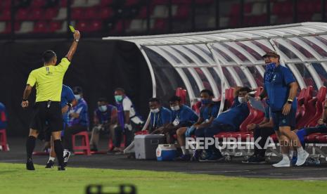 Wasit Fariq Hitaba (kiri) memberikan kartu kuning kepada pelatih Persib Bandung Robert Rene Alberts (kanan) saat timnya berhadapan dengan Persebaya Surabaya dalam pertandingan sepak bola Liga 1 di Stadion I Wayan Dipta, Gianyar, Bali, Sabtu (19/3/2022). Pertandingan berakhir imbang dengan skor 1-1. ANTARA FOTO/Nyoman Budhiana/rwa.