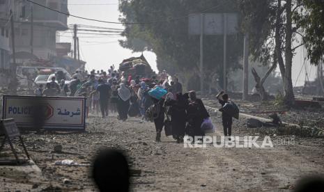 Warga berjalan kaki saat melakukan evakuasi di Jalur Gaza Utara, Ahad (5/11/2023).