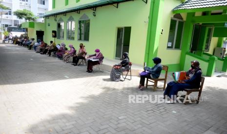 Orangtua Wali murid menggunakan masker antre menunggu konsultasi pendaftaran PPDB.