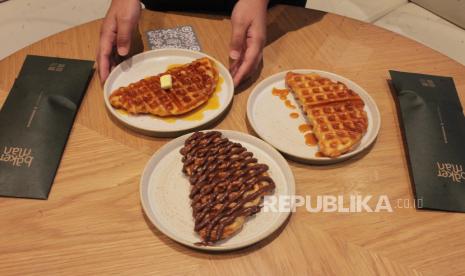 Karyawan menyajikan makanan croffle di Toko Bakerman, Jakarta, Kamis (25/11/2021). Croffle merupakan jajanan kekinian perpaduan dua kudapan yakni croissant dan waffle yang belakangan menjadi viral di berbagai media sosial karena memiliki rasa yang gurih, empuk dan wangi.    