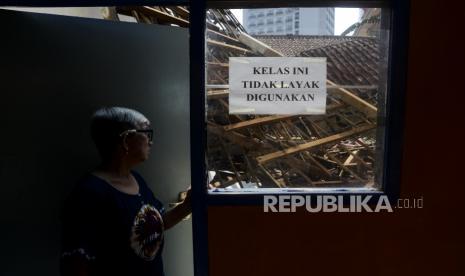 Warga melihat kondisi ruangan kelas yang ambruk di SDN Otista, Baranangsiang, Kota Bogor, Jawa Barat, Jumat (17/9). Sebanyak dua kelas ambruk pada bagian atap bangunan yang sudah tidak layak digunakan untuk kegiatan belajar mengajar karena kondisi kayu yang lapuk. 