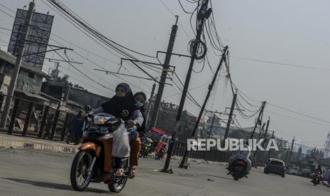 Sejumlah kendaraan melintas di dekat tiang listrik yang berada di tengah jalan di kawasan Pasar Minggu, Jakarta, Rabu (5/8). Guna mendukung keandalan pasokan listrik saat perayaan Natal dan Tahun Baru 2021, PLN menyiagakan 31 ribu personel kelistrikan, termasuk Pasukan Dalam Keadaan Bertegangan (PDKB). 