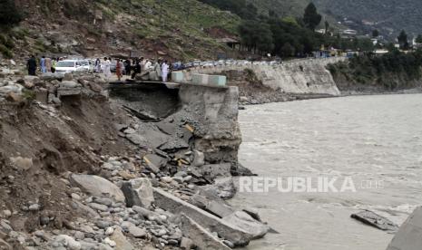 Penumpang menunggu di jalan yang rusak di sebelah banjir, di Bahrain, Pakistan, Selasa, 30 Agustus 2022. Pejabat bencana mengatakan hampir setengah juta orang di Pakistan memadati kamp setelah kehilangan rumah mereka dalam banjir yang meluas yang disebabkan oleh hujan monsun yang belum pernah terjadi sebelumnya di beberapa minggu terakhir.