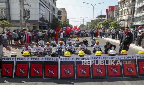 Pengunjuk rasa anti-kudeta menggelar protes duduk setelah polisi anti huru hara memblokir pawai mereka di Mandalay, Myanmar, Rabu, 24 Februari 2021. Para pengunjuk rasa yang menentang perebutan kekuasaan militer di Myanmar kembali ke jalan-jalan kota pada hari Rabu, beberapa hari setelah pemogokan umum menutup toko-toko dan membawa banyak orang untuk berdemonstrasi.