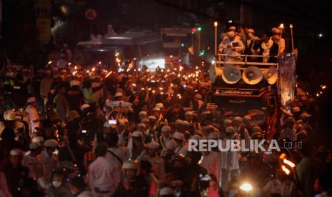 Sejumlah warga mengikuti pawai obor di Jalan Raya Puncak, Kabupaten Bogor, Jawa Barat, Selasa (18/7/2023). Kegiatan tradisi pawai obor dari kawasan Gadog sampai Cisarua tersebut untuk bersuka cita menyambut Tahun Baru Islam 1 Muharam 1445 Hijriah.