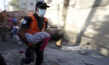 Warga Palestina mengevakuasi korban selamat pascaserangan udara Israel terhadap gedung-gedung di Deir al Balah, Jalur Gaza, Selasa, 7 November 2023.