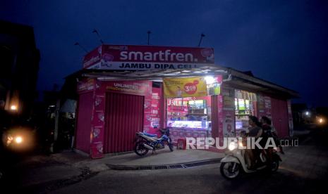 Kendaraan melintas di depan salah satu konter pulsa dengan branding Smartfren, Cilebut, Bogor, Rabu (29/6/2022).