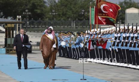 Presiden Turki Recep Tayyip Erdogan, kiri, dan Putra Mahkota Saudi Mohammed bin Salman meninjau pengawal kehormatan militer selama upacara penyambutan, di Ankara, Turki, Rabu, 22 Juni 2022. Putra Mahkota Saudi tiba di Ankara pada Rabu, melakukan kunjungan pertamanya ke Turki setelah pembunuhan kolumnis Saudi Jamal Khashoggi di Istanbul. Arab Saudi dan Turki terus maju dengan upaya untuk memperbaiki hubungan yang tegang akibat pembunuhan Khashoggi.