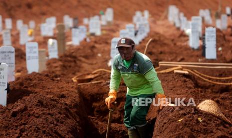 Seorang pekerja menggali kuburan saat upacara pemakaman di Makam Pondok Ranggon di Jakarta, 30 September 2020. Menurut laporan, tanah di Makam Pondok Ranggon yang diperuntukkan bagi penguburan orang yang meninggal karena COVID-19 semakin menipis dan diperkirakan habis dalam dua bulan.