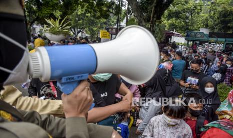 Sejumlah warga antre untuk memasuki kawasan Alun-Alun Bandung, Kota Bandung, Ahad (14/11). Kawasan Alun-Alun Bandung yang menjadi salah satu destinasi wisata kota mulai terlihat ramai dan dipadati pengunjung saat akhir pekan, seiring turunnya angka kasus Covid-19 dan status Kota Bandung yang saat ini menjadi PPKM Level 2. Foto: Republika/Abdan Syakura