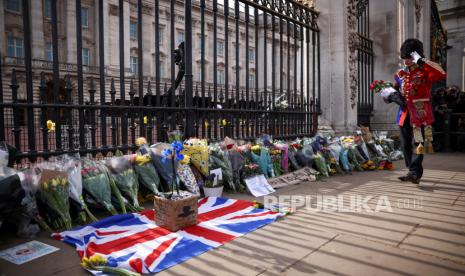 Seorang pria membawa bunga ke Istana Buckingham setelah Pangeran Philip dari Inggris, suami Ratu Elizabeth, meninggal pada usia 99 tahun, di London, Inggris, 9 April 2021.