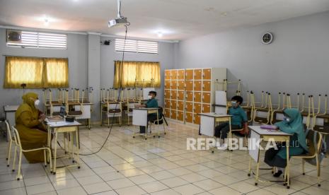 Sejumlah murid mengikuti kegiatan belajar mengajar saat hari pertama pembelajaran tatap muka (PTM) di SD Ar Rafi, Jalan Sekejati, Kiaracondong, Kota Bandung, Rabu (8/9). Pemerintah Kota Bandung kembali menggelar pembelajaran tatap muka (PTM) secara terbatas di 330 sekolah yang meliputi PAUD/TK, SD, SMP dan SMA dengan menerapkan protokol kesehatan ketat serta membatasi jumlah murid sebanyak 50 persen dari kapasitas kelas dan sisanya mengikuti pembelajaran secara daring. Foto: Republika/Abdan Syakura