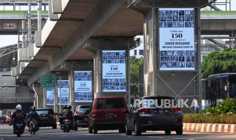 Pengendara melintas di dekat videotron yang menampilkan jumlah tenaga kesehatan yang menjadi korban COVID-19 di kawasan Kebayoran Baru, Jakarta, Jumat (18/9/2020). Tampilan di videotron tersebut untuk mengingatkan masyarakat akan bahaya COVID-19 yang telah menyebabkan lebih dari 150 tenaga kesehatan gugur berjuang melawan pandemi. 