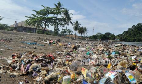 Warga berdiri di dekatan sampah yang berserak di Pantai Berok, Padang, Sumatera Barat, Senin (5/10/2020). Pemkot Padang mengaku menemui kendala dalam menangani tumpukan sampah dari laut, di antaranya kekurangan alat berat karena sulit saat dipindahkan secara manual. 