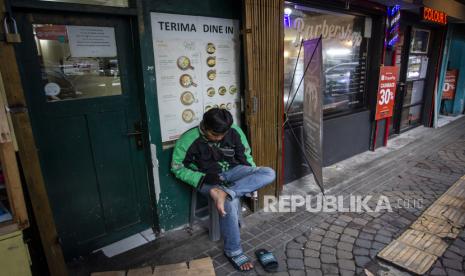 Pengemudi ojek daring menunggu pesanan di depan salah satu restoran di kawasan Sabang, Jakarta, Jumat (8/1/2021). Pemerintah menetapkan kebijakan Pemberlakuan Pembatasan Kegiatan Masyarakat (PPKM) di wilayah Jawa-Bali pada 11-25 Januari mendatang guna menekan angka penularan COVID-19 yang salah satunya membatasi kegiatan di restoran untuk makan atau minum di tempat hanya diperbolehkan sebanyak 25 persen dari kapasitas. 