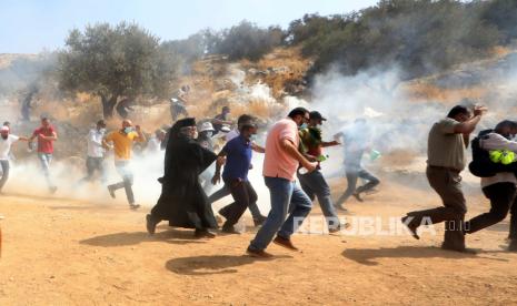  Warga Palestina lari untuk mencari perlindungan dari gas air mata yang ditembakkan oleh tentara Israel selama demonstrasi menentang permukiman Israel di desa Bet Dajan dekat kota Nablus, Tepi Barat utara, Jumat (9/10/2020). 