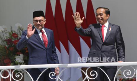 Presiden Indonesia Joko Widodo (kanan) dan Perdana Menteri baru Malaysia Anwar Ibrahim (kiri) melambai kepada wartawan dalam pertemuan mereka di Istana Kepresidenan di Bogor, Indonesia, 09 Januari 2023. Perdana Menteri baru Malaysia Anwar Ibrahim bertemu dengan Presiden Indonesia Joko Widodo untuk pertemuan pertamanya kunjungan resmi sejak dilantik pada akhir November 2022, guna mempererat hubungan kedua negara.