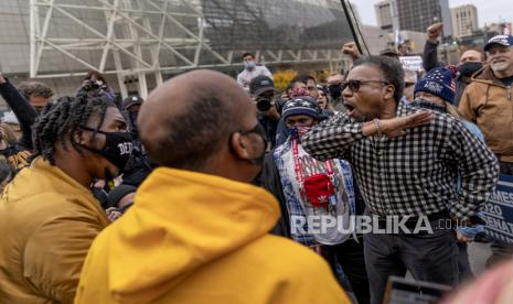  Pendukung Trump C.L. Bryant, kanan, berdebat dengan pengunjuk rasa kontra Angelo Austin, kiri, dan Ralph Gaines, tengah, sementara pendukung Trump berdemonstrasi menentang hasil pemilihan di luar papan penghitungan pusat di tcf Center di Detroit, Kamis, 5 November 2020